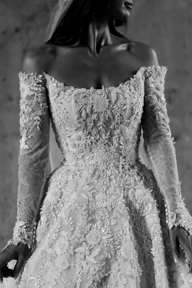 a woman in a white wedding dress with long sleeves and a veil on her head