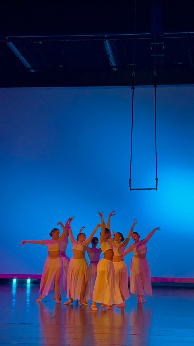 a group of people standing on top of a stage in front of a blue wall