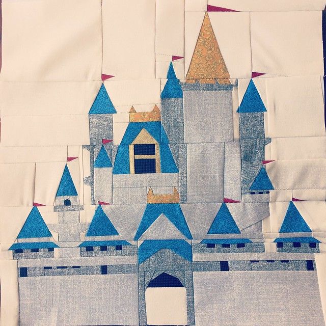 a quilted castle with blue turrets and gold spires is shown on a white piece of cloth