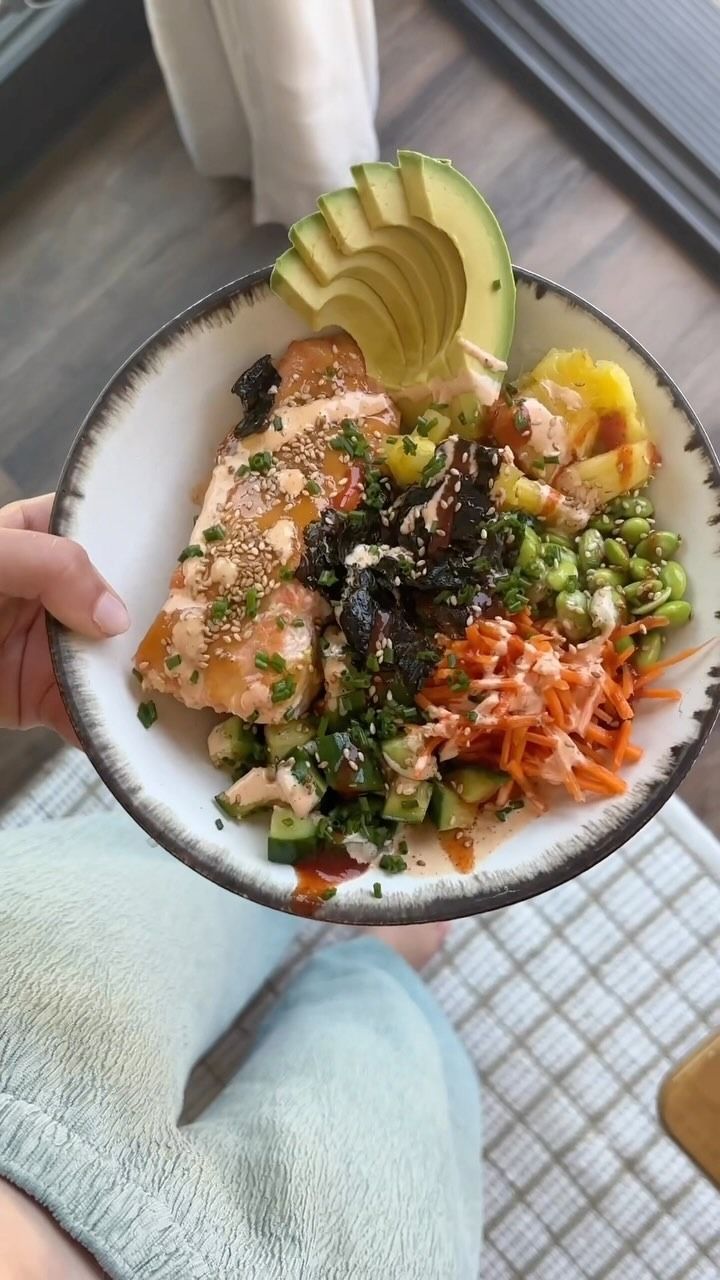 a person holding a white bowl filled with food