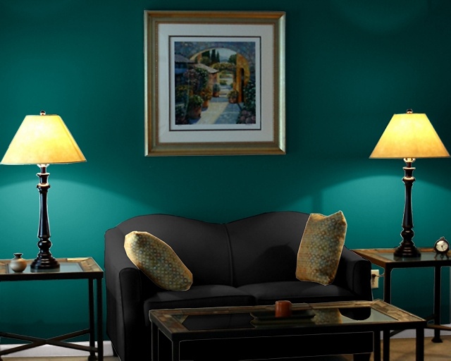 a living room with green walls and two lamps on either side of the couches