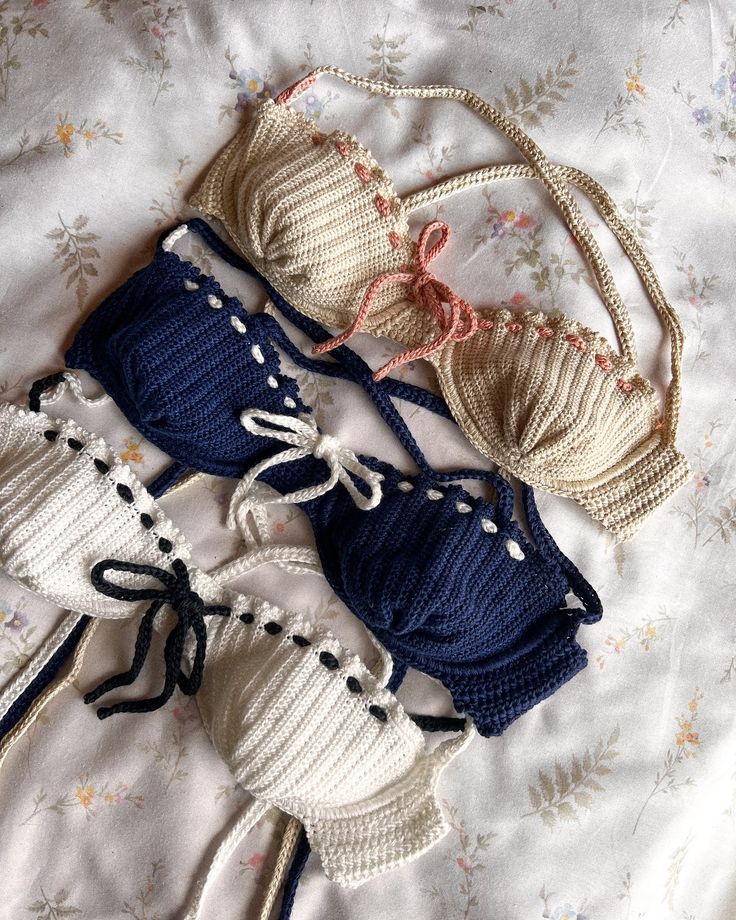 three knitted items laid out on a bed