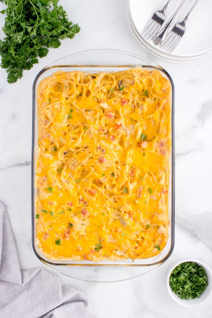 a casserole dish with cheese and vegetables in it on a marble countertop