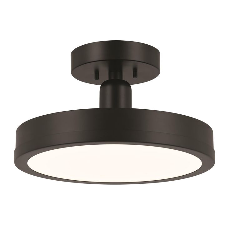 a black ceiling light that is on top of a white wall and has a circular light fixture