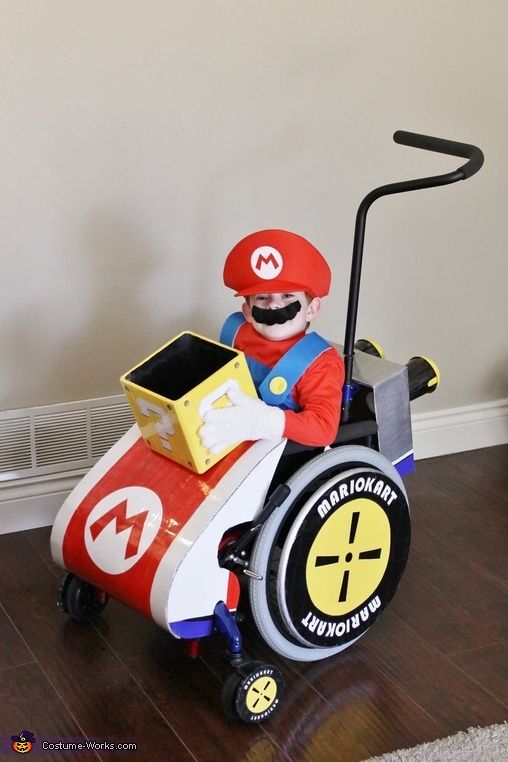 a man in a mario kart costume sitting on top of a wooden floor next to a radiator