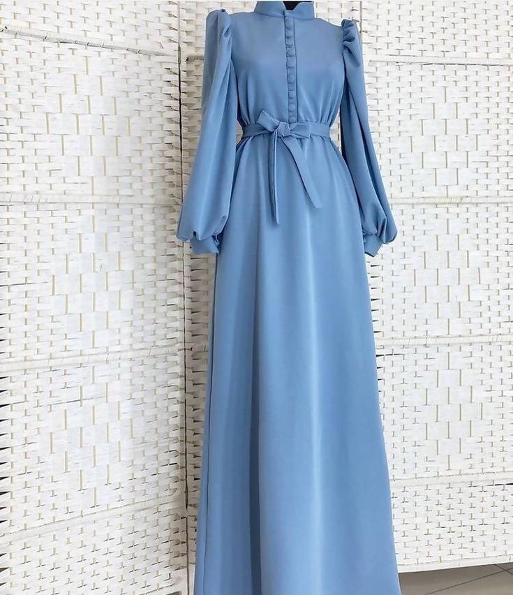 Lined with buttons and elegant cuff sleeves, this abaya dress is a must-have! Modest Long Sleeve Maxi Dress With Buttons, Modest Long Sleeve Maxi Dress For Formal Occasions, Modest Long Sleeve Maxi Dress For Formal Events, Elegant Long Maxi Dress With Modesty Panel, Solid Long Sleeve Dresses For Eid, Elegant Long Sleeve Maxi Dress For Eid, Elegant Eid Maxi Dress, Elegant Solid Color Abaya With Modesty Panel, Elegant Blue Long Sleeve Abaya