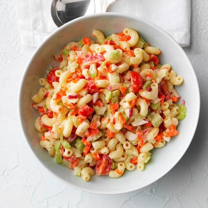 a white bowl filled with macaroni salad on top of a table