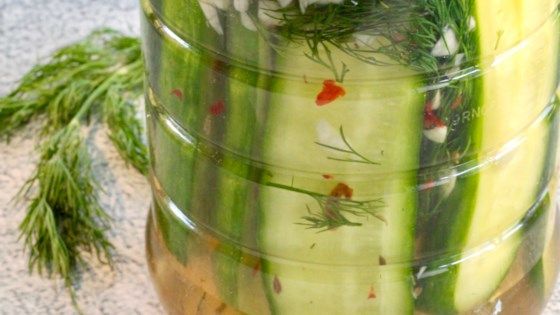 cucumbers and herbs are in a jar on the floor next to some dilling