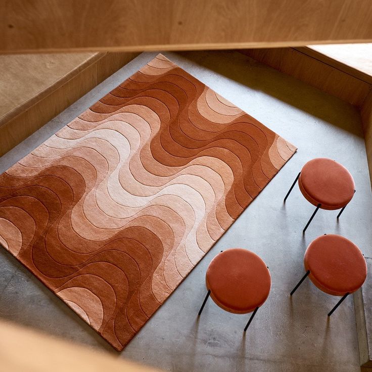 an orange rug and three red chairs on the floor