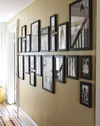 a wall with many framed pictures on it