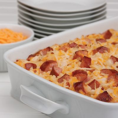 a casserole dish with bacon and cheese in it next to other dishes on the table