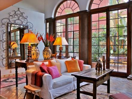 a living room filled with lots of furniture and large windowed windows next to each other