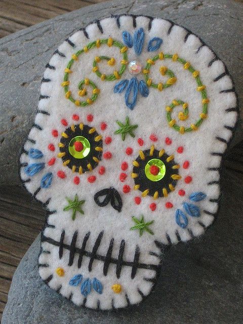 a handmade sugar skull sitting on top of a rock