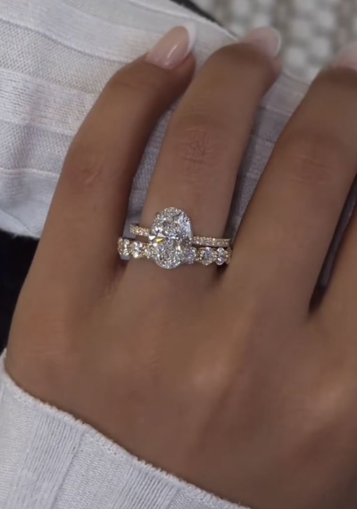 a woman's hand with two engagement rings on it