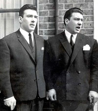 two men in suits standing next to each other