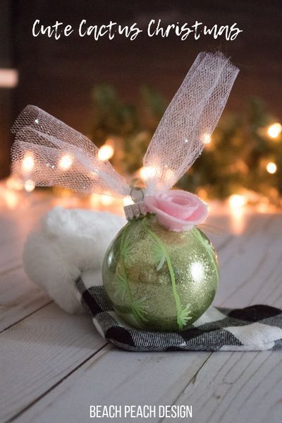 a green ornament with a pink rose on it