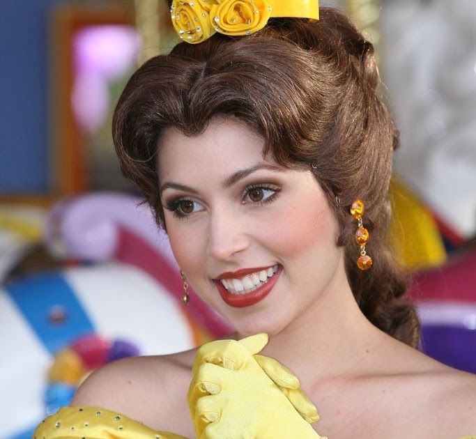 a woman wearing yellow gloves with a flower in her hair and smiling at the camera