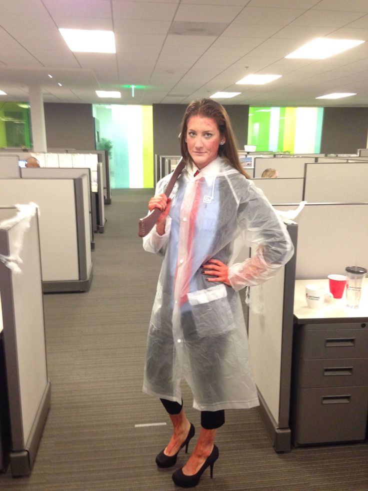 a woman is standing in an office cubicle wearing a plastic coat and high heels