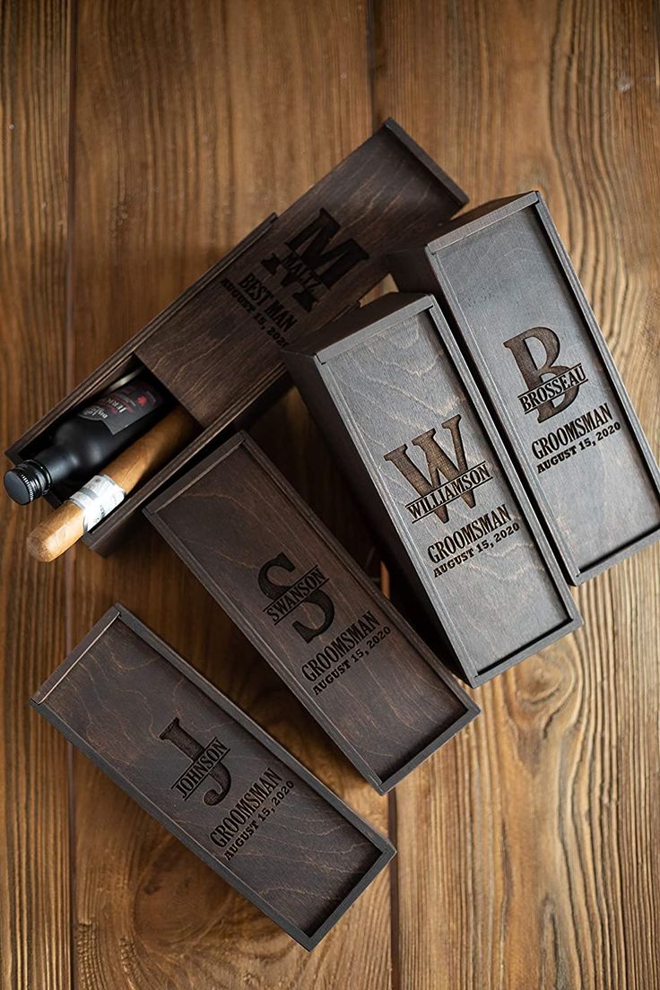 three cigars in wooden boxes sitting on top of a wooden table next to each other