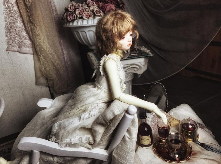 a doll sitting in a chair next to some bottles