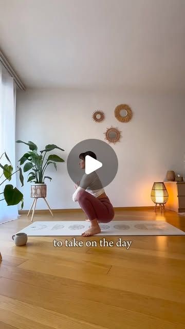 a woman is doing yoga on the floor in front of a window with potted plants