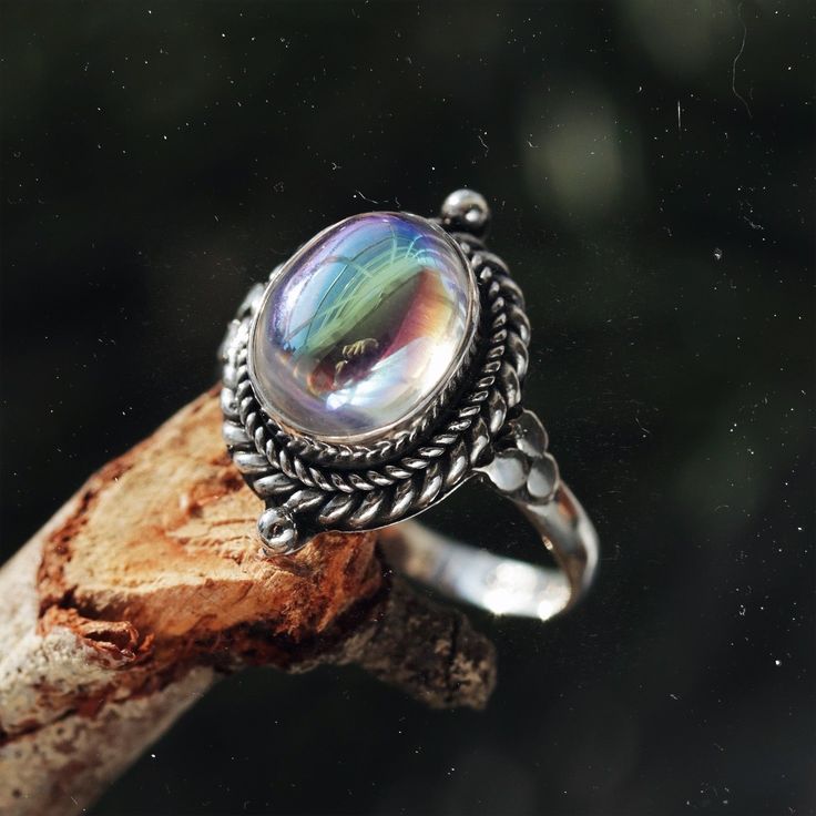 Stand out from the crowd with our boho chic iridescent mystic opal sterling silver ring. Our Little Luna is a beautiful ring with delicate detailing featuring an enchanting witchy mystic stone centre. A Shop Dixi classic to enhance your bohemian jewellery collection. MaterialSterling SilverSynthetic Mystic Opal SizingRing Front - Height 18mm Mystical Iridescent Sterling Silver Jewelry, Handmade Magical Silver Rings, Bohemian Handmade Iridescent Rings, Adjustable Silver Magical Style Rings, Mystical Iridescent Moonstone Jewelry, Mystical Handmade Iridescent Ring, Mystical Moonstone Promise Ring, Handmade Mystical Iridescent Ring, Handmade Magical Silver Crystal Ring