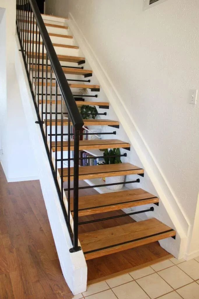 there is a set of stairs with wooden treads on the bottom and black handrails