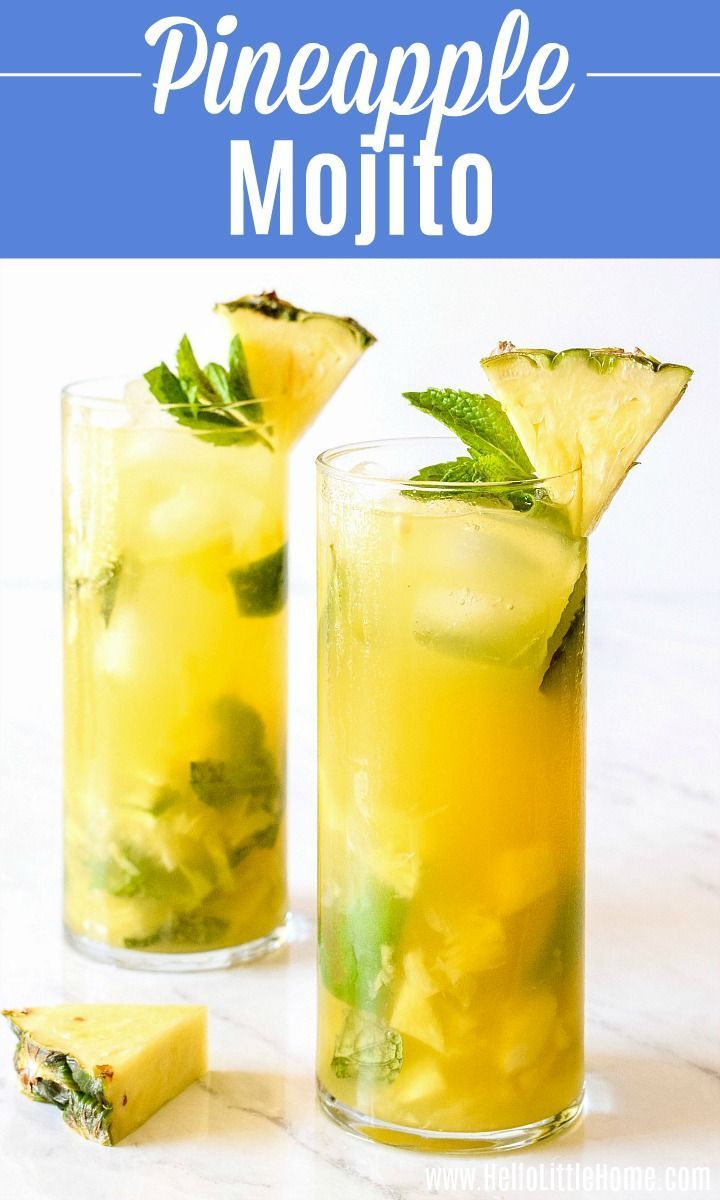 two glasses filled with pineapple mojito on top of a white counter