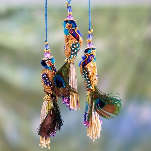 two colorful bird ornaments hanging from strings