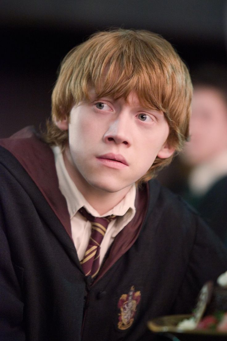 black and white photograph of a young man with long hair wearing a harry potter sweater