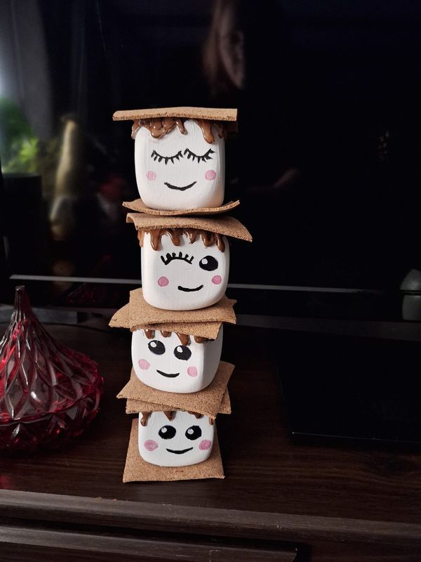 three ceramic pots with faces painted on them sitting on a table next to a vase