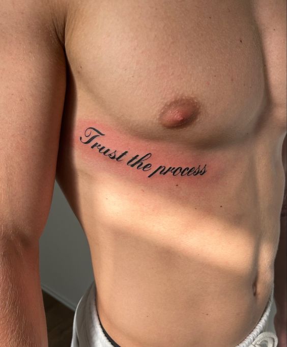 a man with a tattoo on his chest that says trust the process and has words written across it