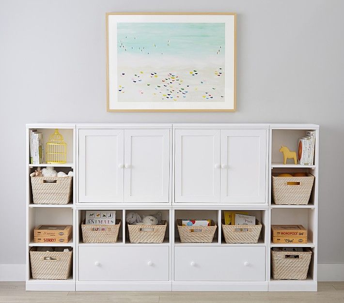 a white bookcase with baskets on top