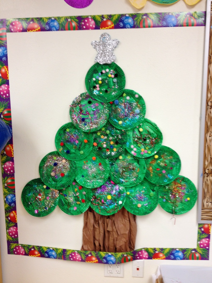 a christmas tree made out of paper plates on a bulletin board with confetti around it