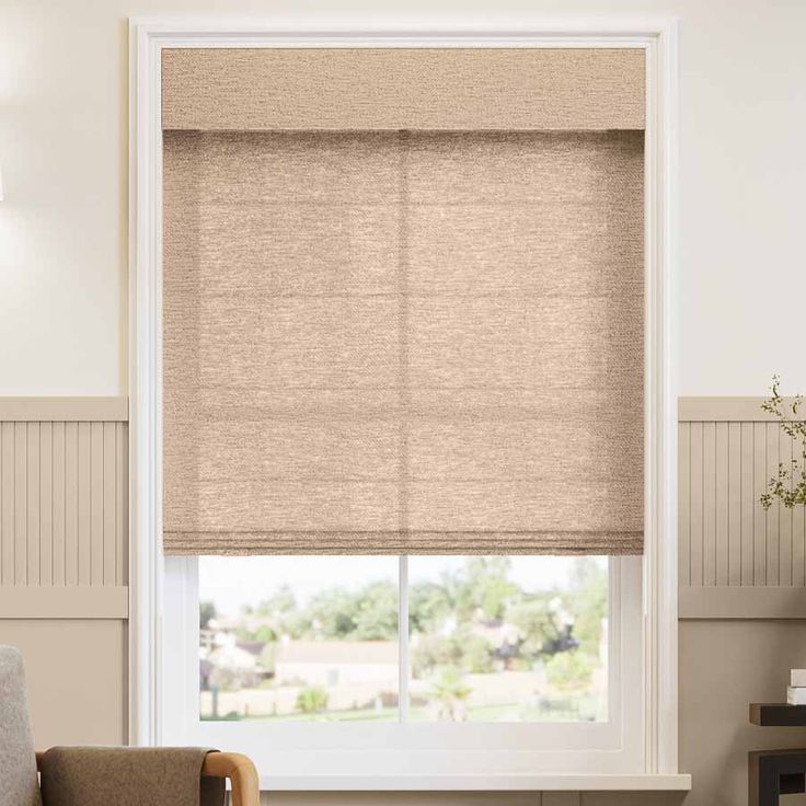 a living room with a couch, chair and window covered in roman blind shades on the windowsill