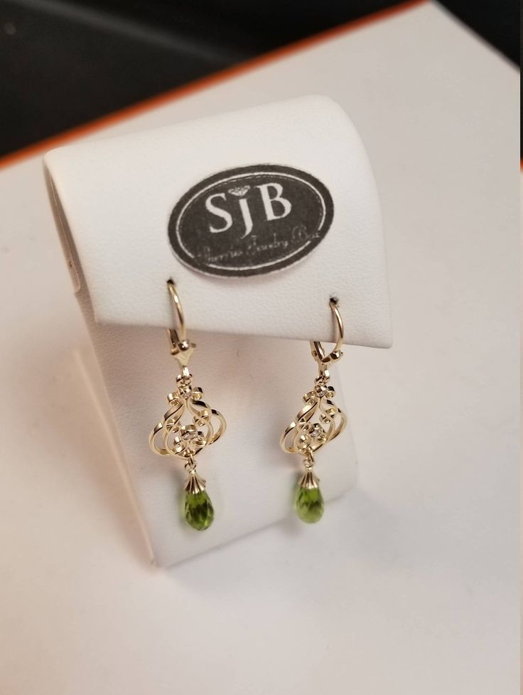 "Bright green Peridot faceted briolette dangle earrings. Set in 14kt Yellow Gold bell caps, with scallop-edged decorative details and large symeterical filigree dangle all hanging from a fleur-de-lis leverbacks. Measures approximately 2\" long. August Birthstone. Pantone Green 2017 color of the year. Please feel free to contact me anytime, if you have any questions or need any additional information. All items are available for local pickup. Contact me for your \"free shipping\" coupon code befo Fine Jewelry With Peridot And Matching Earrings, 14k Gold Green Pierced Earrings, Elegant Green 14k Gold Earrings, Peridot Dangle Earrings In Gold, Elegant Pierced Peridot Jewelry, Yellow Gold Peridot Earrings For Gift, Gold Peridot Earrings Fine Jewelry, Formal Peridot Drop Earrings, Green 14k Gold Dangle Earrings