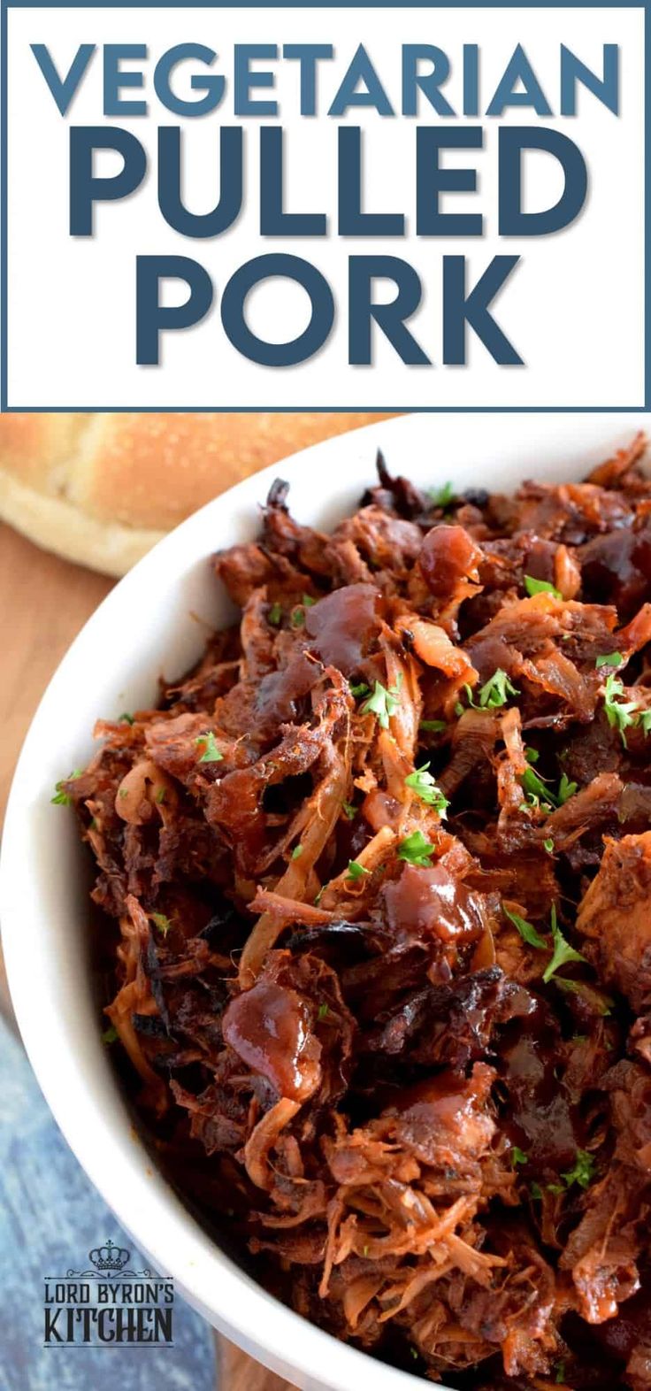 a white bowl filled with pulled pork on top of a wooden table