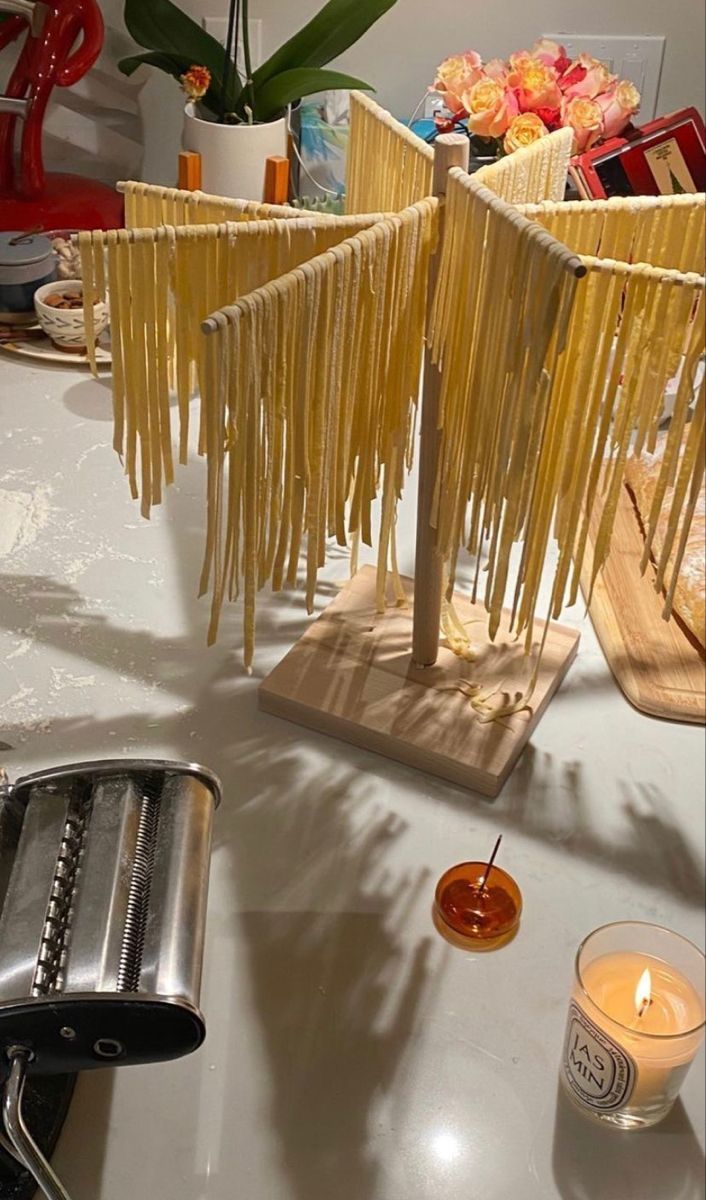 some kind of pasta sculpture on a table with candles and other food items around it