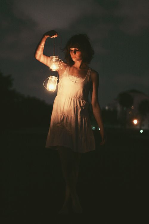 a woman holding a lantern with the words, trust in god why should i be afraid?