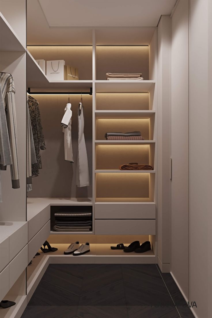 a walk in closet with white cabinets and drawers