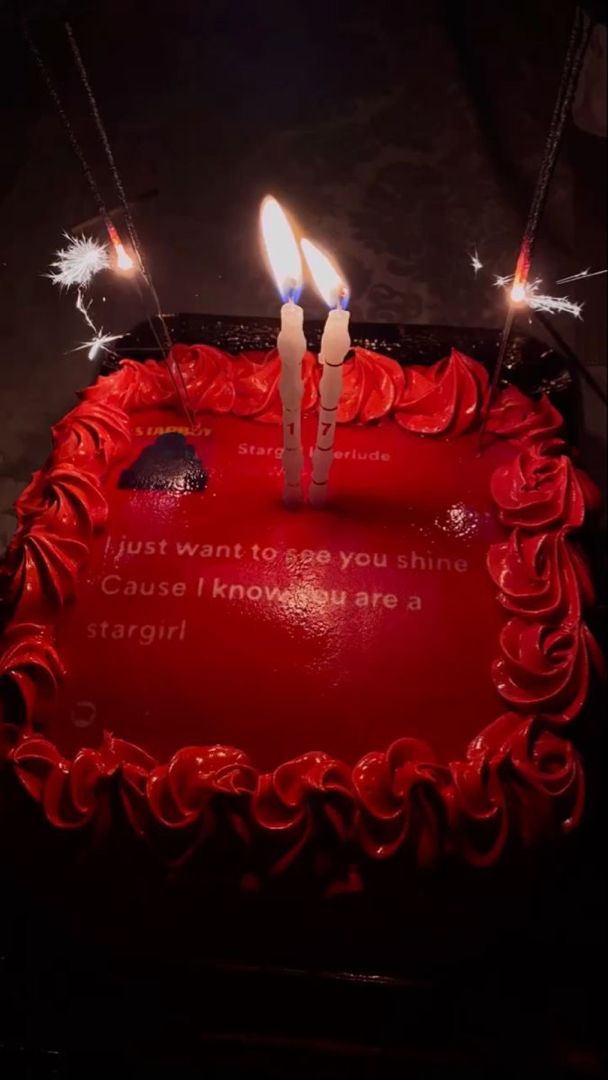 a red birthday cake with two candles on it