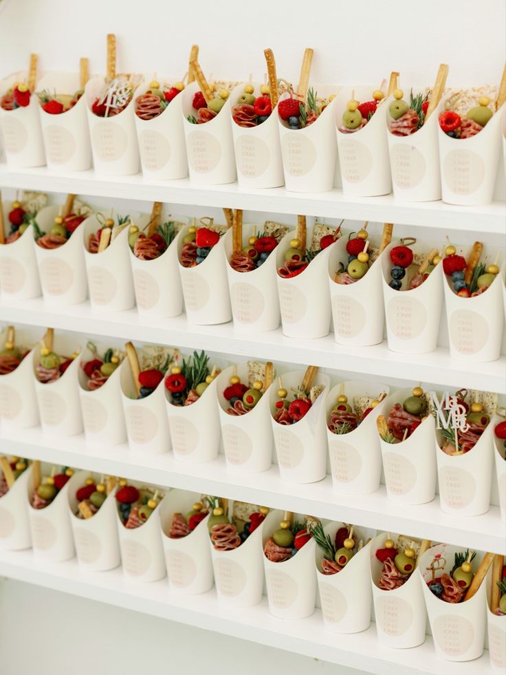 the wall is filled with small cups and baskets full of fruit, including strawberries