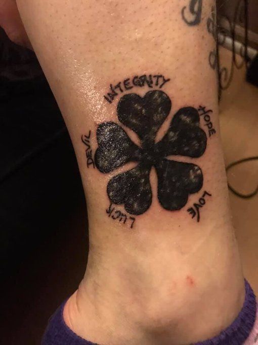 a woman's foot with a four leaf clover tattoo on the side of her leg