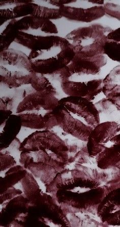 an image of some black and white feathers on a tablecloth with red ink in it