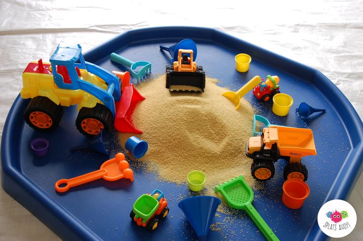 a blue tray filled with toys and sand