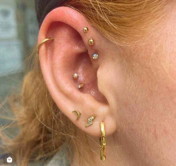 a close up of a person's ear with three different piercings on it