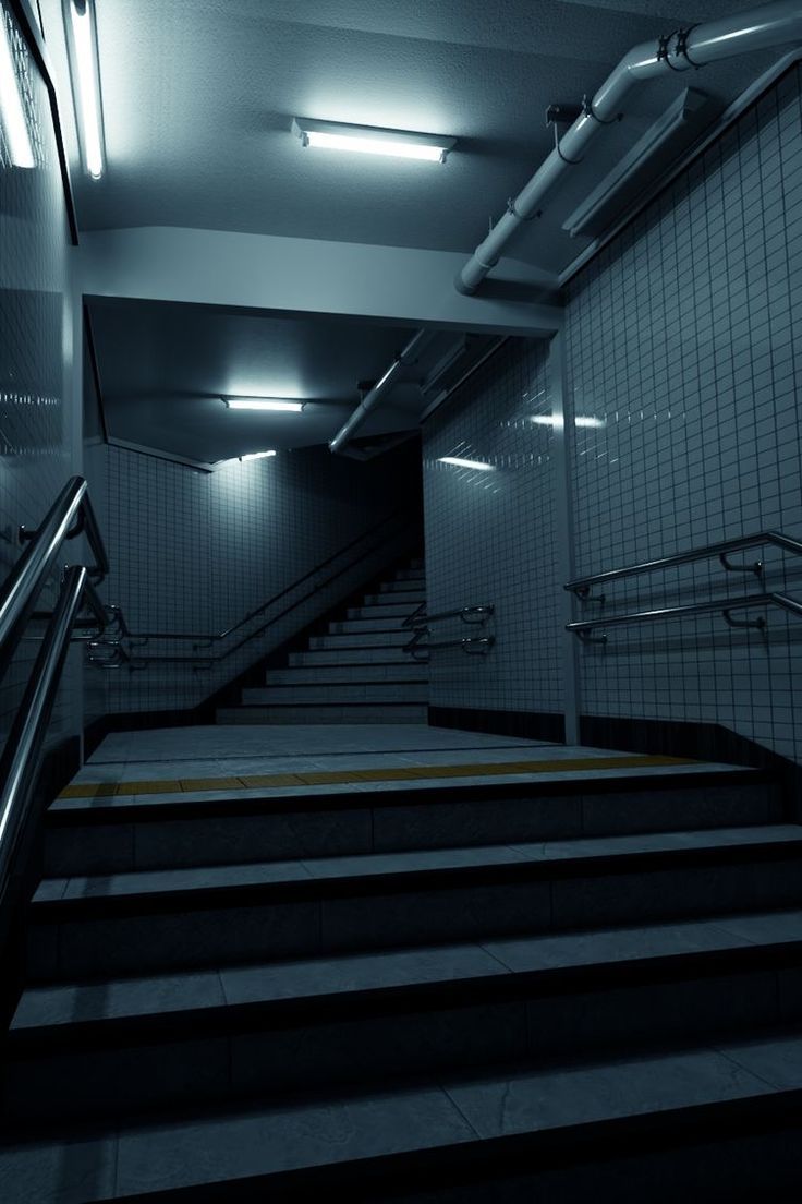 an escalator in a subway station with stairs leading up to the exit door