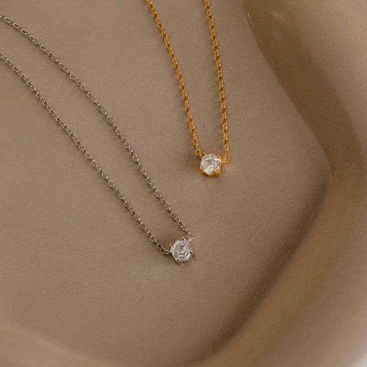 Explore modern elegance with our Hexagon Diamond Necklace, featuring a captivating rose-cut diamond at its core. This dainty and geometric piece effortlessly combines sophistication with contemporary charm, offering a unique allure for any occasion. Material: High Quality 925 Solid Sterling Silver Finish: 18K Gold ∙ Sterling Silver Featuring a ~4.5mm x 4mm Hexagonal Rose-Cut CZ Diamond Charm on a dainty Cable Chain, adjustable from 16 to 18 inches Part of our Diamond & Pavé Collection SKU: RR-NR Modern Necklace With Diamond Cut For Gifts, Modern Necklaces With Diamond Cut For Gifts, Modern Diamond Cut Necklace As A Gift, Modern Single Diamond Necklace For Wedding, Modern Single Diamond Wedding Necklace, Elegant Everyday Solitaire Pendant Necklace, Modern Diamond Cut Diamond Necklace As Gift, Modern Solitaire Necklace With Diamond Cut, Modern Solitaire Pendant Necklace As Gift