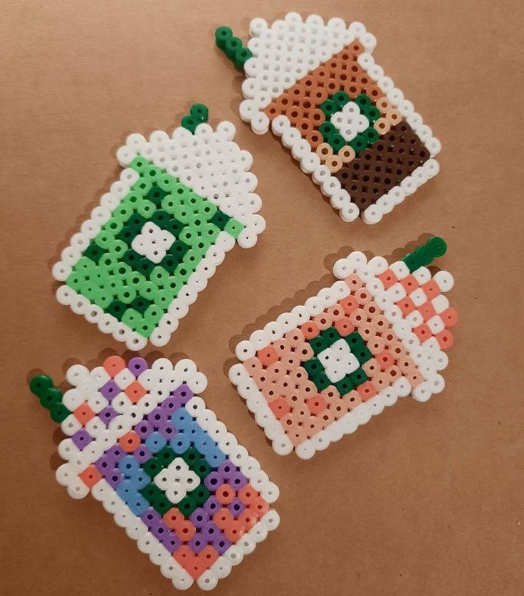 four pieces of perler bead art on a table