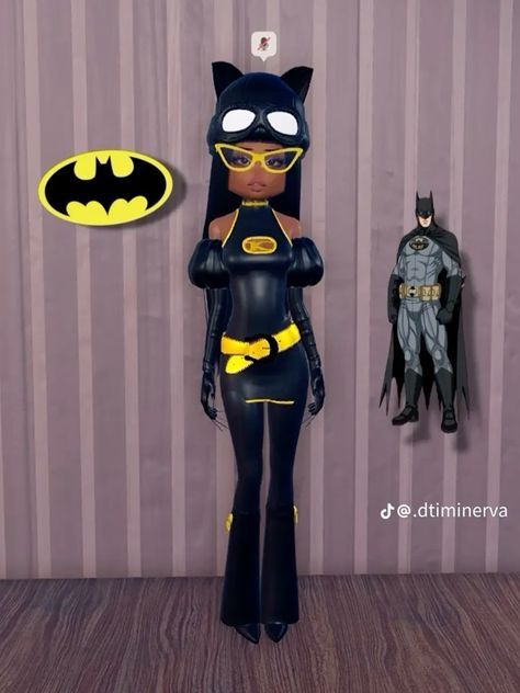 a batman doll is standing next to a batwoman figure and a wallpapered background